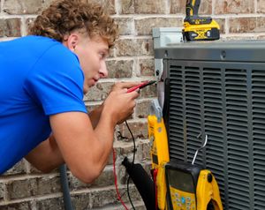 R2 technician testing a residential air conditioning condenser